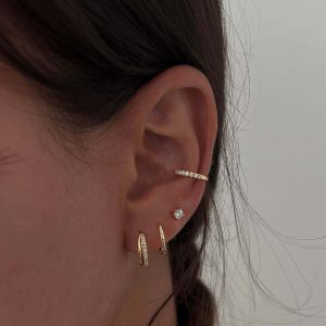 Liz Hoop Earrings showcased in an ear, featuring delicate zirconia stones for everyday sparkle.