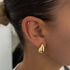 Alex Earrings worn on a model's ear, showcasing their dainty and lightweight design for a glowing look.