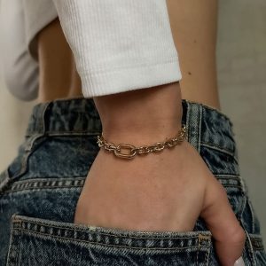 Amour Bracelet worn on a wrist with a stylish outfit featuring denim shorts and a long-sleeve top.