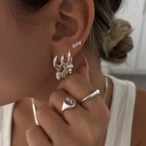 Amy Earrings Set - 925 Sterling Silver displayed on model's ear featuring freshwater pearls and various styles.