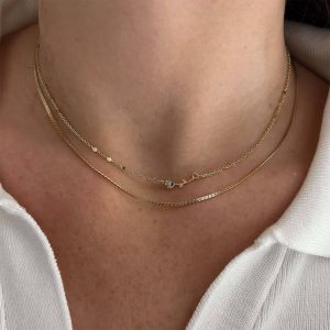 Anne Necklace featuring two layered gold chains and a delicate rose charm for a romantic touch.