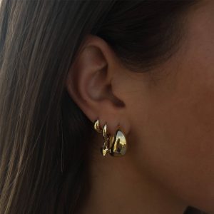 Close-up of a model wearing Anna Heart Earrings, showcasing dainty and minimal heart-shaped design.