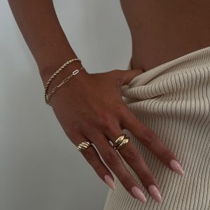 Anuk Bracelet worn with rings and chains on a model's hand against a neutral background, highlighting elegance and style.