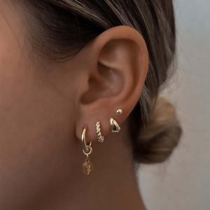 Close-up of earrings in ear featuring Baby Reef Earrings stacked with other earrings for a trendy look.
