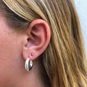 Baby Tommy Earrings - 925 Sterling Silver showcased in a close-up of a model's ear with long blonde hair.