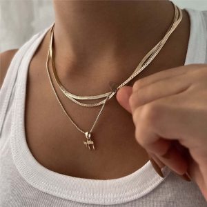 Chai Necklace showcasing a delicate 'Chai' pendant worn with layered gold and silver chains, symbolizing life and strength.