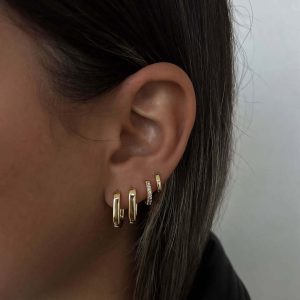 Close-up of a model's ear showcasing Danny Earrings – geometric gold studs that are stylish and versatile.