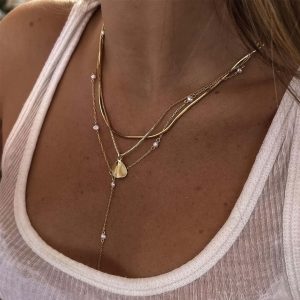 Dani Necklace displayed on a model, featuring layered gold chains with delicate pearls for everyday elegance.