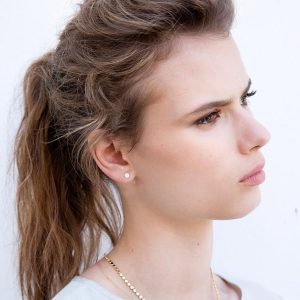 Model showcasing Dot Earrings, simple and timeless tiny circle studs for a minimal look.
