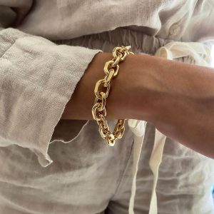 Dylan Bracelet worn on a woman's wrist, showcasing its 14K gold plated brass design and elegant style.