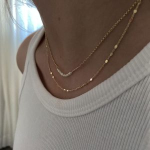 Elly Necklace displayed on a model, showcasing layered gold chains for a minimal and stylish look.