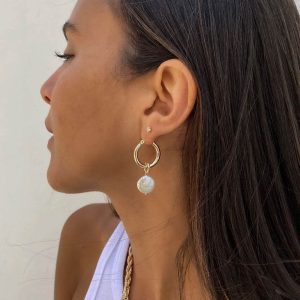 Emma Earrings featuring elegant hoop design and flat freshwater pearl drop accent worn by a woman.