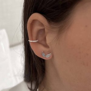 Close-up of dainty Wings Earrings worn on an ear, showcasing a light, dreamy wing design.