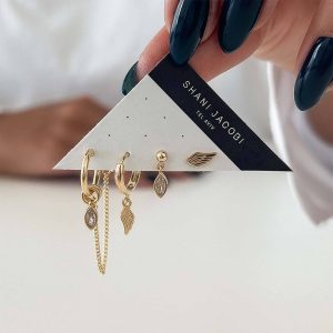 Hermas Earrings Set featuring gold wing-inspired designs and delicate crystals for stylish asymmetrical looks.