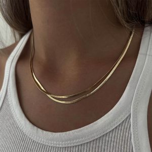 Tiny Jessica Necklace layered with other delicate gold necklaces for a stylish look.
