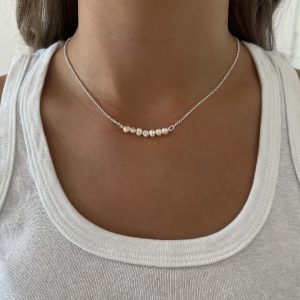 Mulan Necklace - 925 Sterling Silver worn by a model, featuring freshwater pearls on a delicate chain.