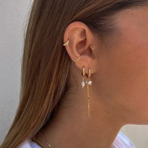 Nelly Earrings featuring delicate double chains with freshwater pearls hanging from sleek hoops worn by a model.