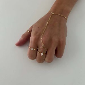 Pearl Ring showcased on a hand with delicate gold chains and dainty crystal rings for an elegant look.