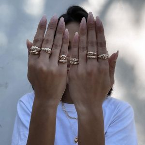 Model showcasing multiple rings including the stylish Reef Slim Ring on both hands.
