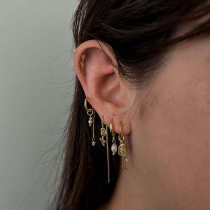 Model wearing the Rose Earring Set featuring various unique earrings and natural freshwater pearls.