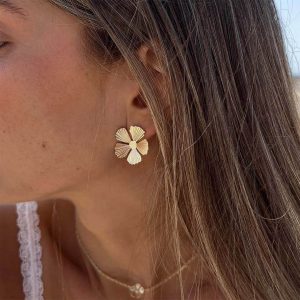 A woman wearing Nuri Earrings, featuring a delicate floral design that elevates her stylish look.