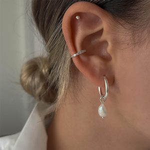 Small Pearl Earrings - 925 Sterling Silver worn in a woman's ear, showcasing elegance and style for any occasion.