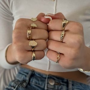 Model showcasing multiple rings including the Vered Ring, a signet ring with a rose engraving.